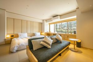 a bedroom with a bed and a couch and a window at Zazan minakami in Minakami +80 photos
