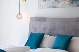 a bed with blue pillows in a room at Lit Living - Deluxe Apartments - Box Spring - Parking - Neueröffnung - NEW OPENING in Worms