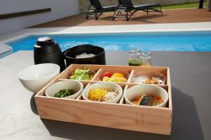 a wooden tray filled with different types of food at Mare Blu Amami in Tatsugo