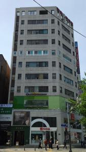 a tall building with people walking in front of it at Kanso Stay Jongno in Seoul