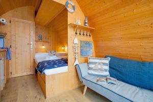 a room with a bed and a couch in a cabin at Hausboot Dotterbart in Stralsund