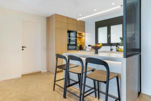 a kitchen with two bar stools at a counter at Urban Heights Ammoudi Seafront in Agios Nikolaos