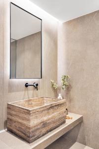 a bathroom with a wooden tub and a mirror at Urban Heights Ammoudi Seafront in Agios Nikolaos +27 photos