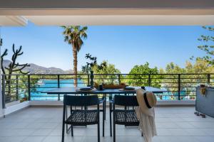 a table and chairs on a balcony with a view of the ocean at Urban Heights Ammoudi Seafront in Agios Nikolaos