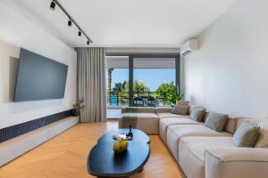 a living room with a couch and a flat screen tv at Urban Heights Ammoudi Seafront in Agios Nikolaos