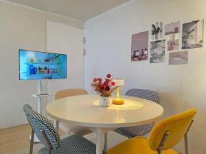 a white table with chairs and a vase of flowers on it at 스테이 온기 in Suwon