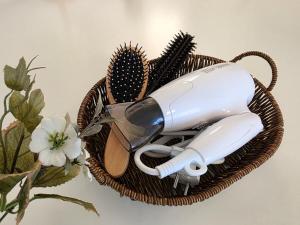 a hair dryer and brushes in a wicker basket at 스테이 온기 in Suwon +39 photos