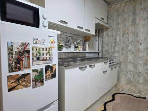 a kitchen with white cabinets and a refrigerator at 스테이 온기 in Suwon