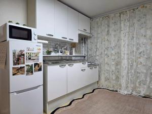 a kitchen with white cabinets and a refrigerator at 스테이 온기 in Suwon