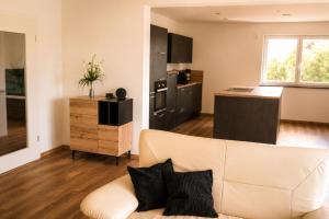 a living room with a couch and a kitchen at Moderne Bauernhof Wohnung mitten in der Natur in Emtmannsberg