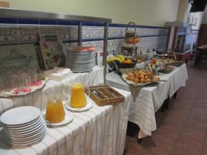 a buffet line with plates and pitchers of orange juice at Hotel del Mar in Sant Feliu de Guíxols