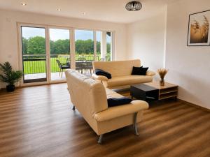 a living room with two chairs and a couch and a table at Moderne Bauernhof Wohnung mitten in der Natur in Emtmannsberg
