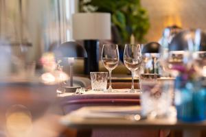 a table with wine glasses on top of it at Leopold Hotel Oudenaarde in Oudenaarde