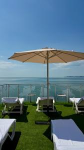 a patio with an umbrella and some chairs and tables at Отель у моря Chester in Odesa