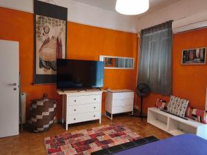 a living room with a flat screen tv on a dresser at Appartamento in centro con terrazza in Viareggio
