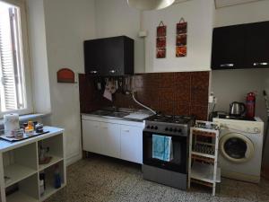 a kitchen with a stove and a washing machine at Appartamento in centro con terrazza in Viareggio +5 photos