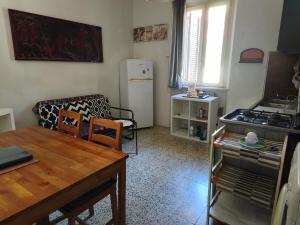 a living room with a table and a kitchen with a stove at Appartamento in centro con terrazza in Viareggio