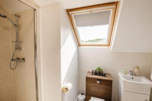 a bathroom with a toilet and a window at Groups Haven 5 Bed 2 Bath Hot Tub Pool Table in Attercliffe +137 photos