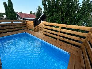 a swimming pool with a wooden fence and a swimming poolitures at בורקאי - בקתות פיליפיניות עם בריכה פרטית in Bruchim Qela' Alon