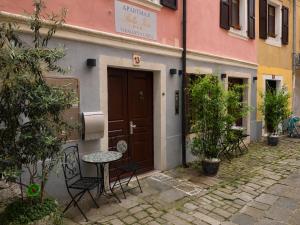 a door to a building with a table and chairs at Apartments Bella Tara in Piran