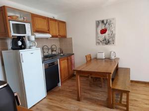 a small kitchen with a table and a refrigerator at Bel appartement montagne in Albiez-Montrond