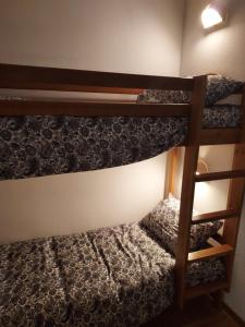 two bunk beds in a small room with a ladder at Bel appartement montagne in Albiez-Montrond