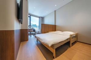 a bedroom with a bed and a television in it at Weave Suites - Sunyu Parkside in Seoul