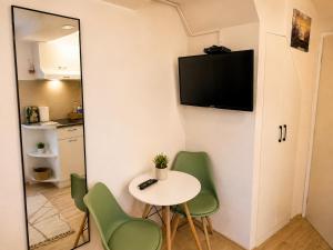 a room with a table and chairs and a tv on the wall at Sky Terrace retreat in Draga Bašćanska