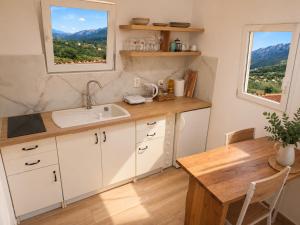a kitchen with a sink and a table and a window at Sky Terrace retreat in Draga Bašćanska