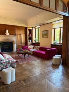 a living room with a red couch and a fireplace at Le Palais d'Orient - Suite avec salle d'eau in Hannut