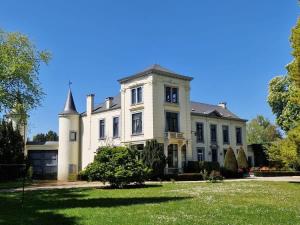 a large white house with a turret on a lawn at Le Palais d'Orient - Suite avec salle d'eau in Hannut