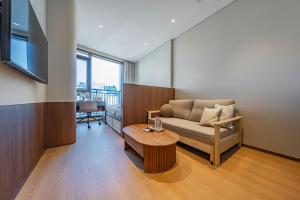 a living room with a couch and a table at Weave Suites - Sunyu Parkside in Seoul
