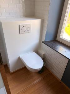 a white toilet in a bathroom with a window at Le Palais d'Orient - Suite avec salle d'eau in Hannut