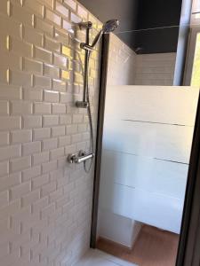 a shower with a white brick wall in a bathroom at Le Palais d'Orient - Suite avec salle d'eau in Hannut
