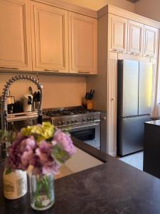 a kitchen with a counter with a vase of flowers at Le Palais d'Orient - Suite avec salle d'eau in Hannut +27 photos