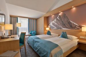 a hotel room with a large bed and a desk at Hotel Goldener Adler Wattens in Wattens +48 photos