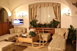 a living room with two couches and a tv at Hotel Trieste in Cortina dʼAmpezzo