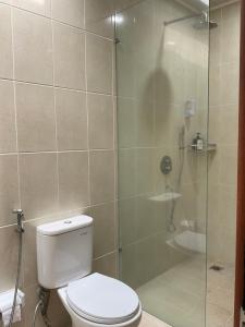 a bathroom with a toilet and a glass shower at Sariuma babadan in Badung