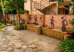 a wall with a mural of people on it at Sheen Villa Homestay in Varkala +5 photos
