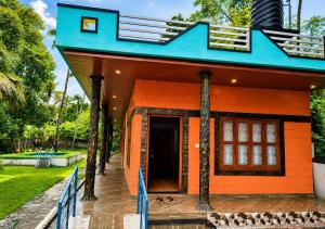 a small orange house with a blue roof at Sheen Villa Homestay in Varkala