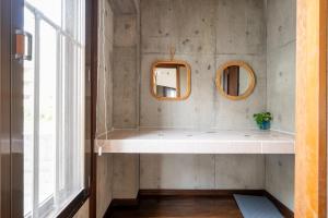 a bathroom with two mirrors and a sink at Alumina アルミナ in Kin +108 photos
