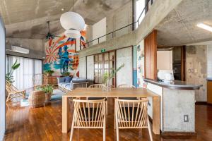 a dining room with a wooden table and chairs at Alumina アルミナ in Kin