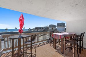 a balcony with a table and chairs and an umbrella at A304 - Sail Away Stay in Oceanside
