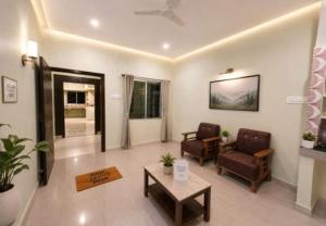 a living room with two chairs and a table at Dev'S Inn Luxurious Homestays in Similigurha