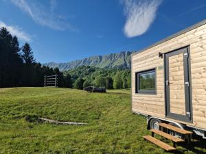 a tiny house in a field with mountains in the background at BONIS - Nidi nel Bosco in Montemaggiore