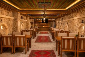 a restaurant with wooden chairs and tables and a bar at Premium Cappadocia in Göreme