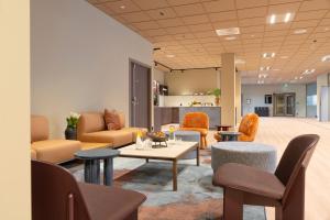 a living room with chairs and a couch and tables at Thon Hotel Drammen in Drammen