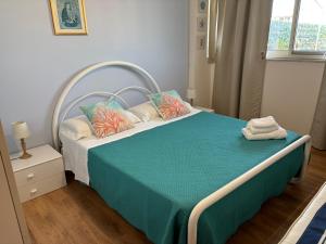 a bedroom with a bed with a blue blanket and pillows at Terrazza Fiumara in Letojanni