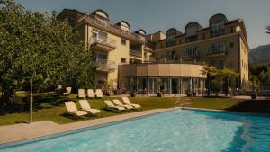 ein Hotel mit einem Schwimmbad vor einem Gebäude in der Unterkunft Hotel Villa Laurus in Meran
