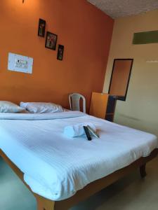 a bed with a remote control on top of it at VISHAKA RESIDENCY yercaud in Siddhma +2 photos